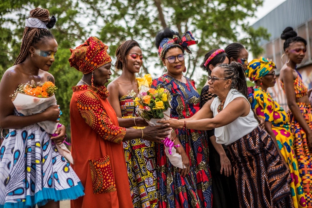 La Embajadora María del Rosario Mina Rojas entrega flores a lxs cinco costurerxs que culminaron exitosamente el taller: Elizabeth, Tembi, Oma, Fortunate y Pinkie.  Foto: Salym Fayad para Embajada de Colombia en Sudáfrica.