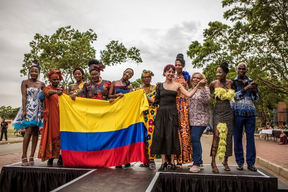 La diseñadora colombiana Laura Laurens aparece acompañada de lxs cinco costurerxs que culminaron exitosamente el taller: Elizabeth, Tembi, Oma, Fortunate y Pinkie. Foto: Salym Fayad para Embajada de Colombia en Sudáfrica.